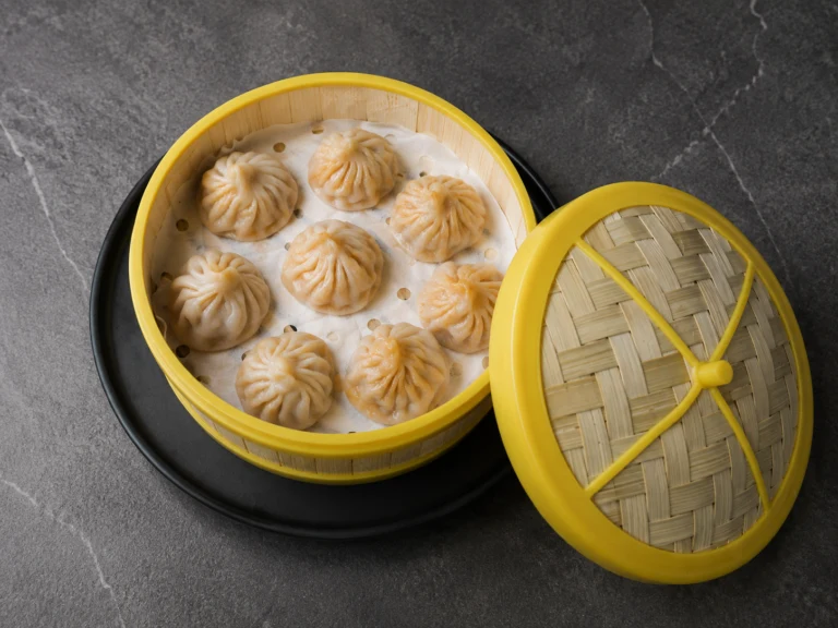Taste of Beauty xiaolongbao in a yellow steamer basket